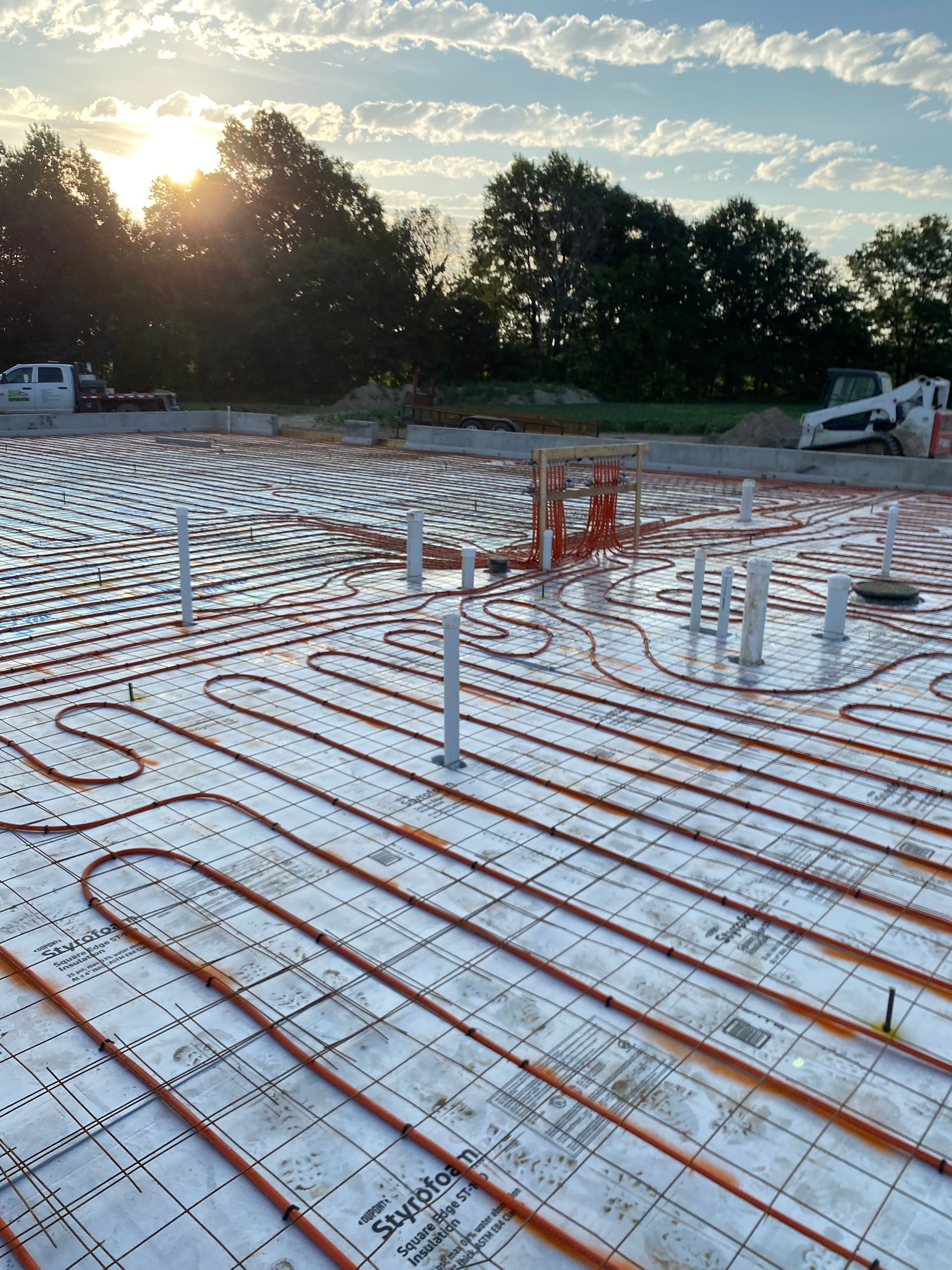 A construction site with a lot of pipes on the ground