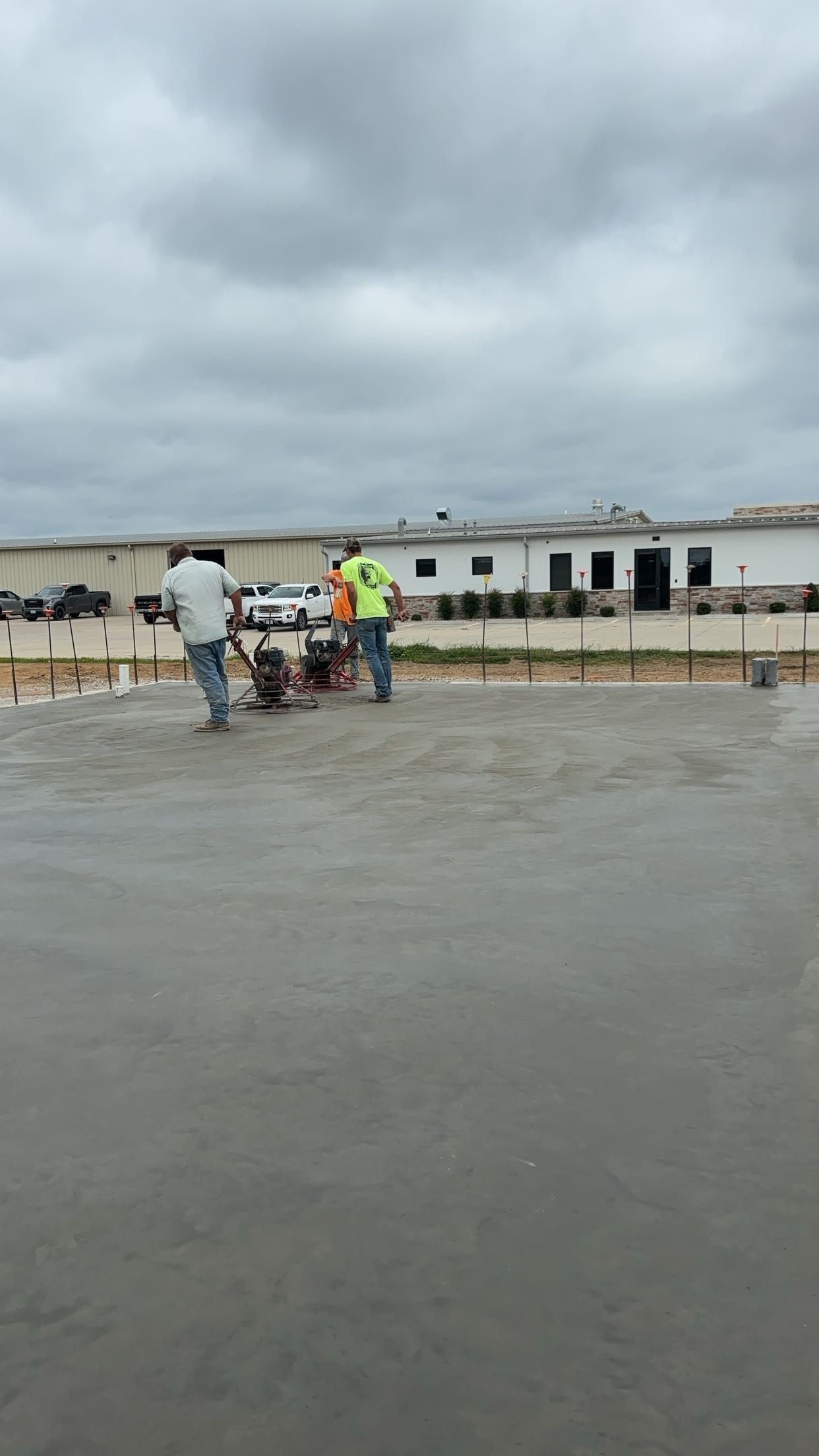 A group of construction workers are working on a concrete floor.