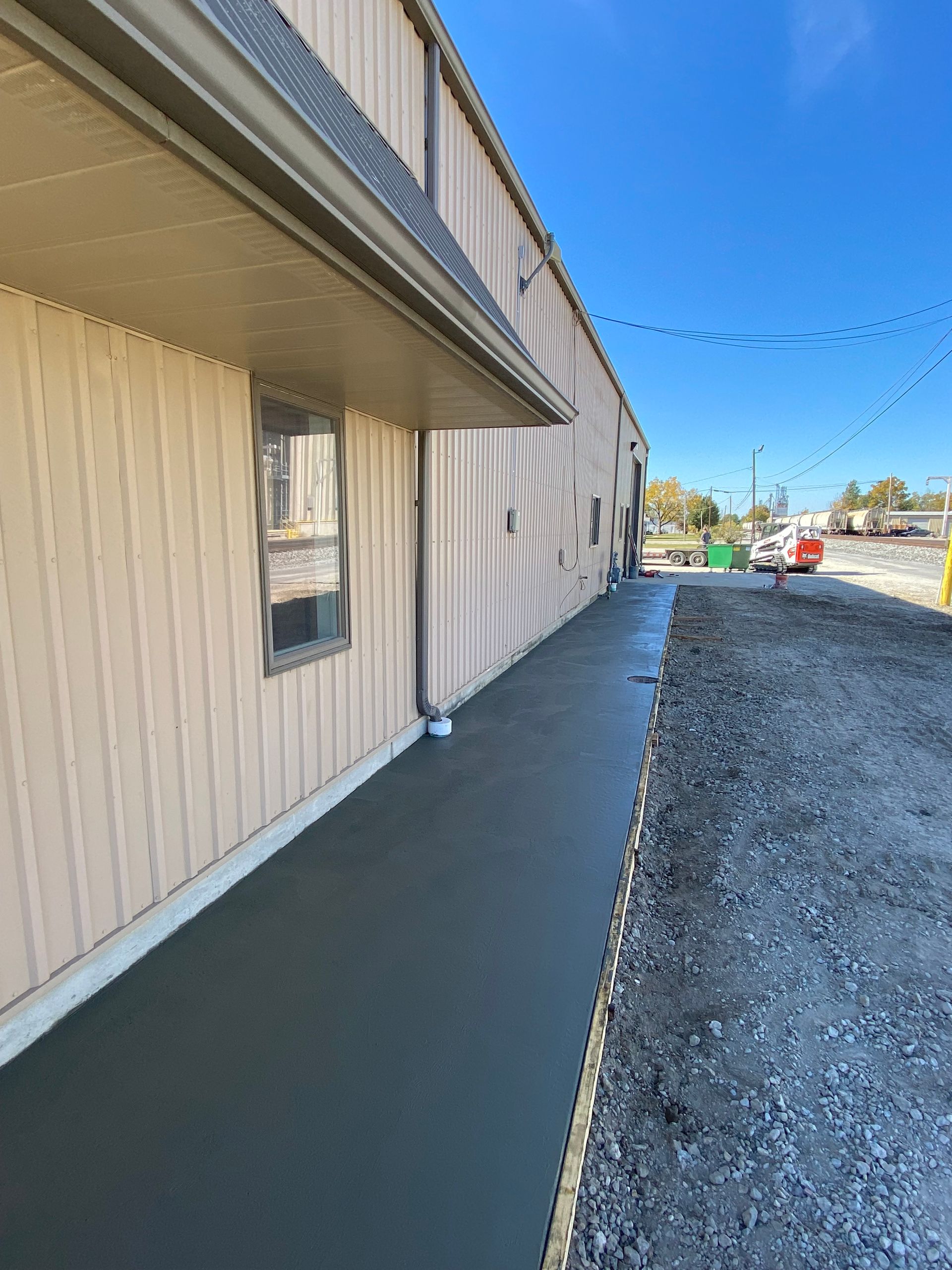 A sidewalk is being built in front of a building.