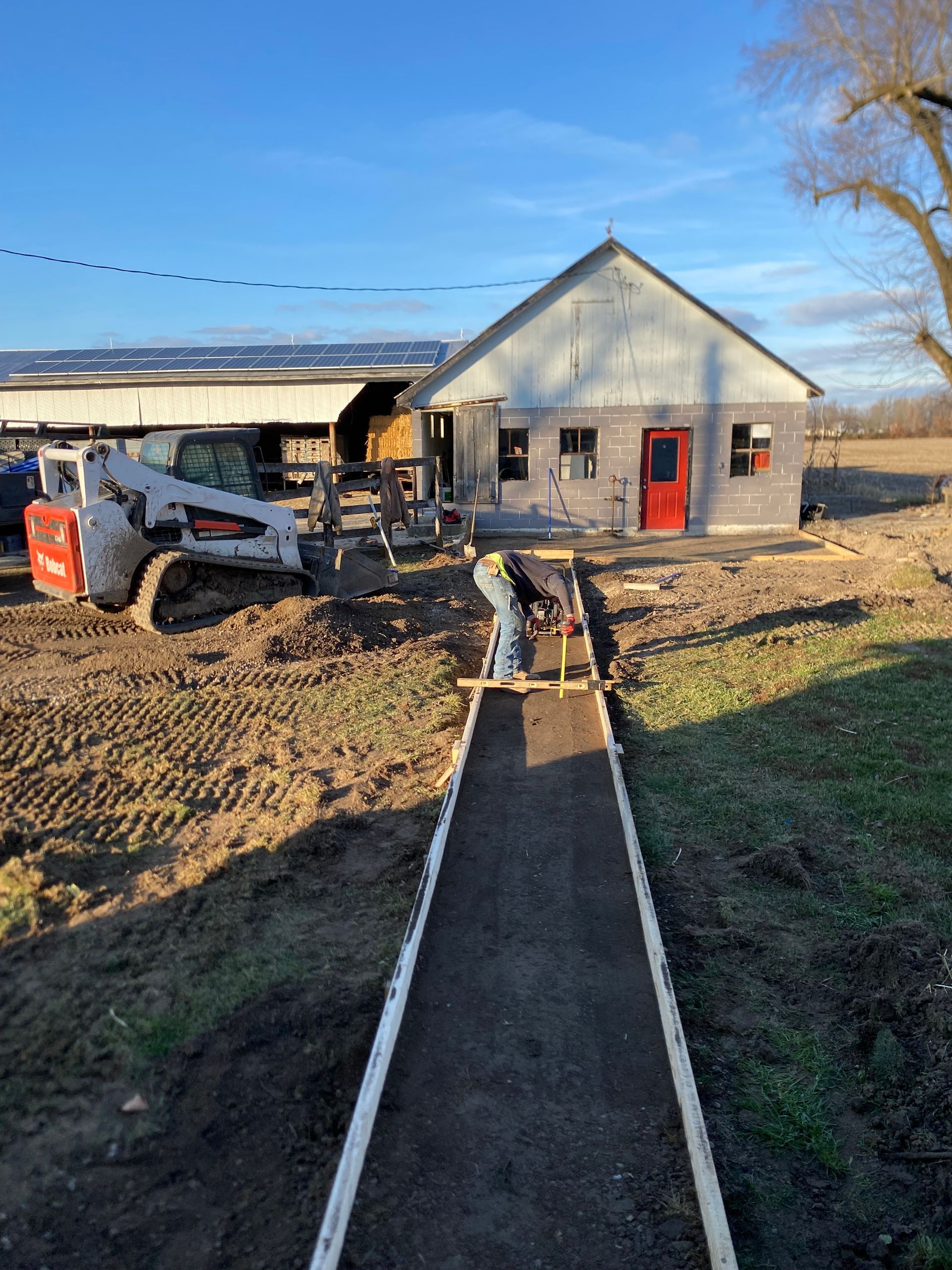 A concrete walkway is being built in front of a house.