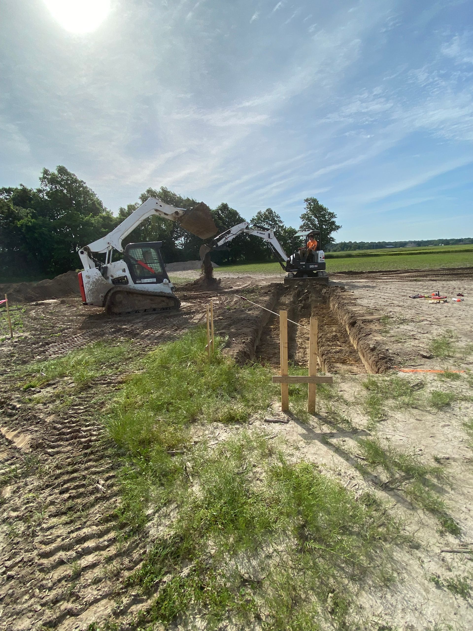 A bulldozer is digging a hole in the dirt in a field.