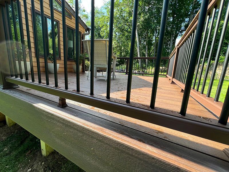 Wooden deck with black railings; outdoor setting.