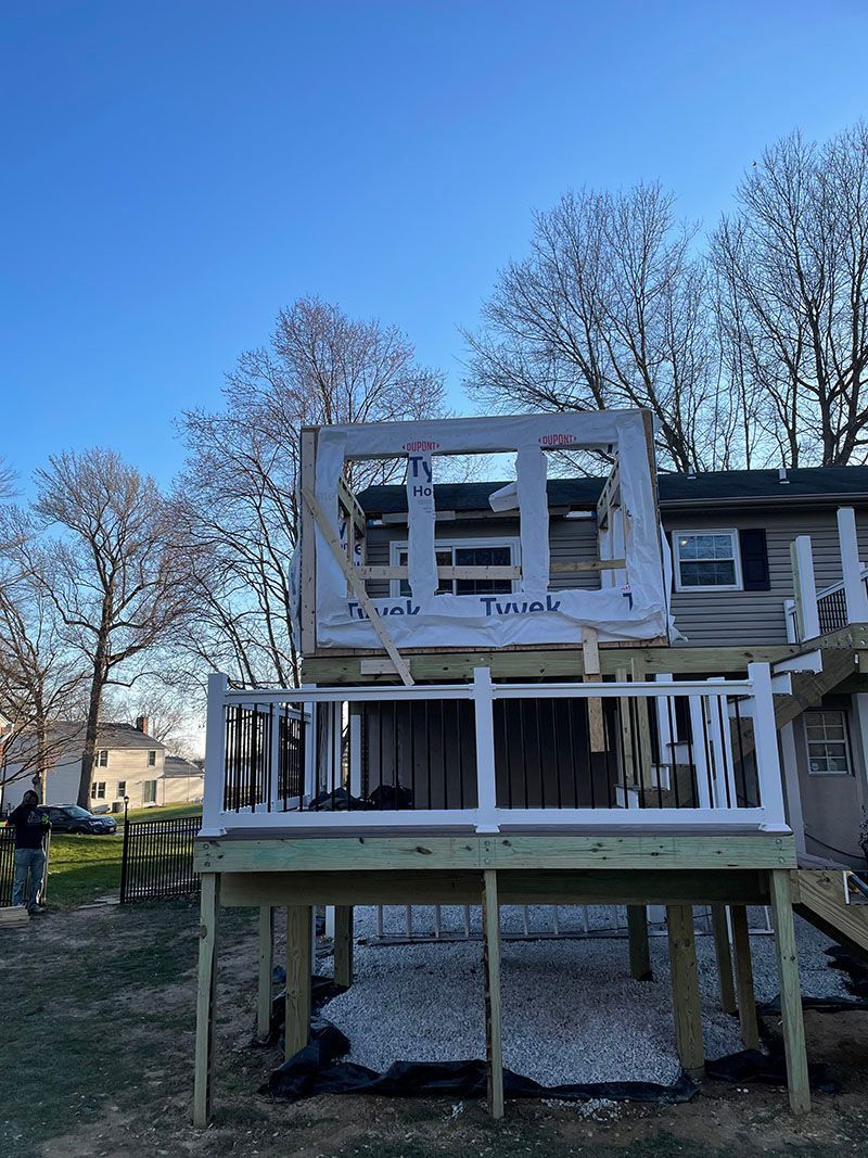 A partially built deck with a framed structure on top; a person in the background.