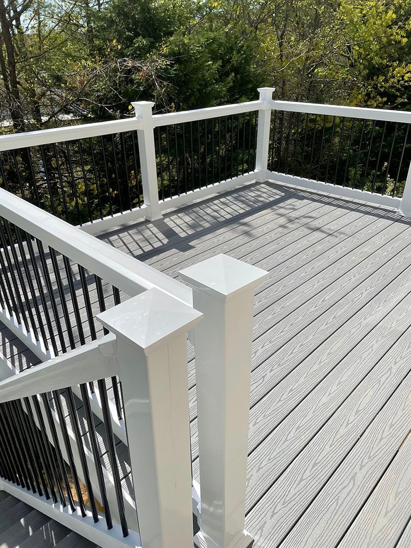 White and black deck railing surrounding a gray composite deck.