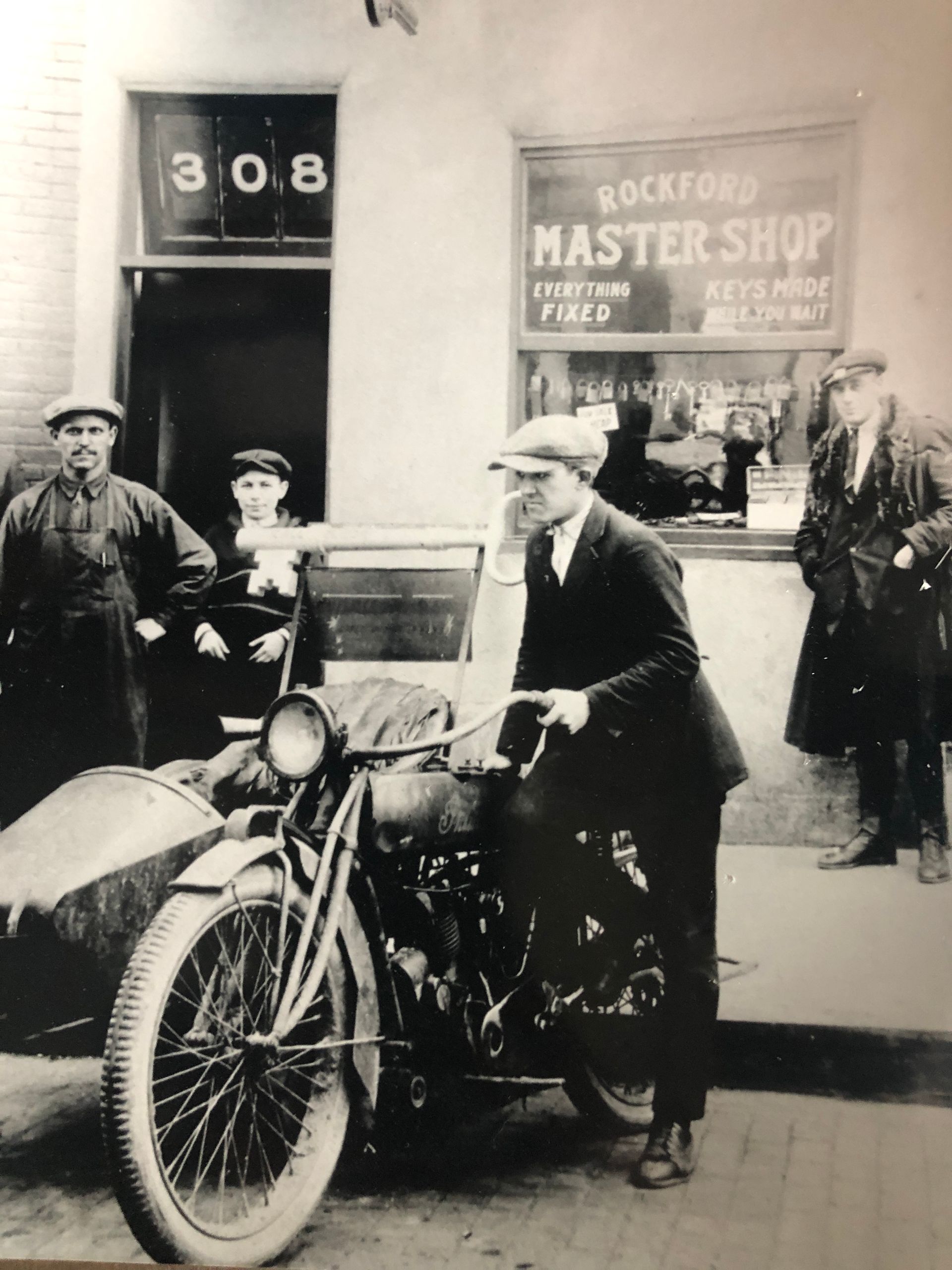 Man in suit with sidecar motorcycle outside a 