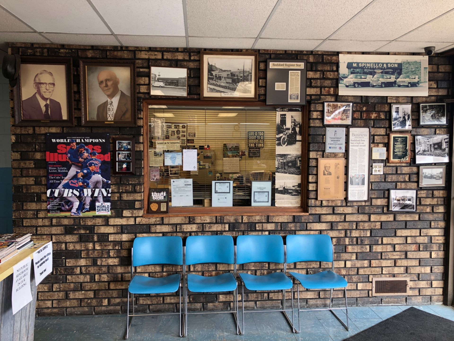 Brick wall with vintage photos, blue chairs, and a window display.