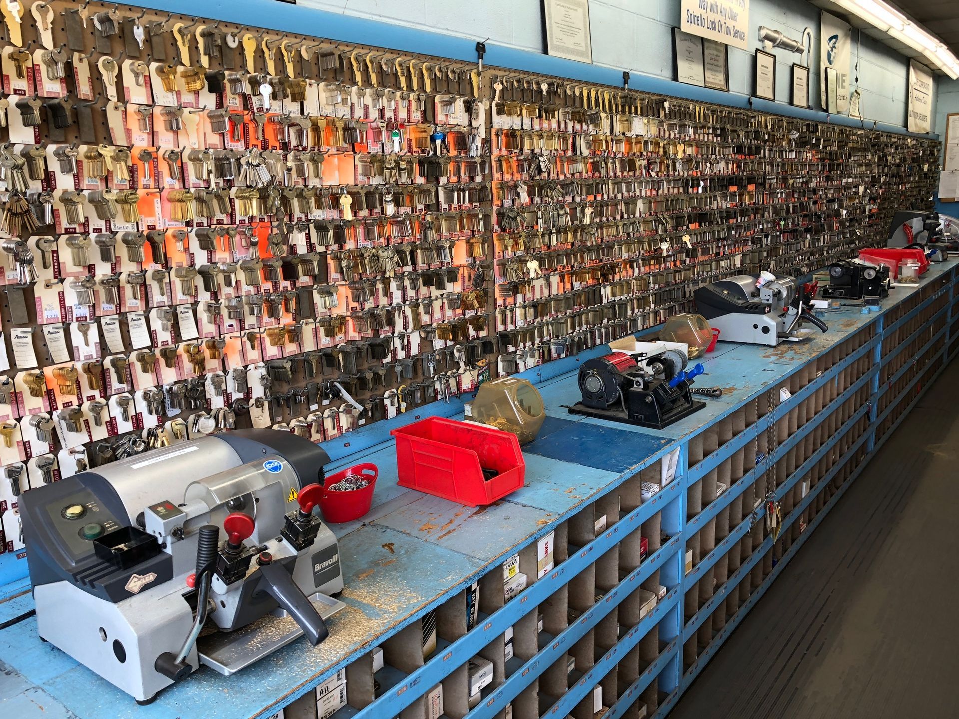 A locksmith shop interior, featuring a wall of keys and key-cutting machines on a counter.