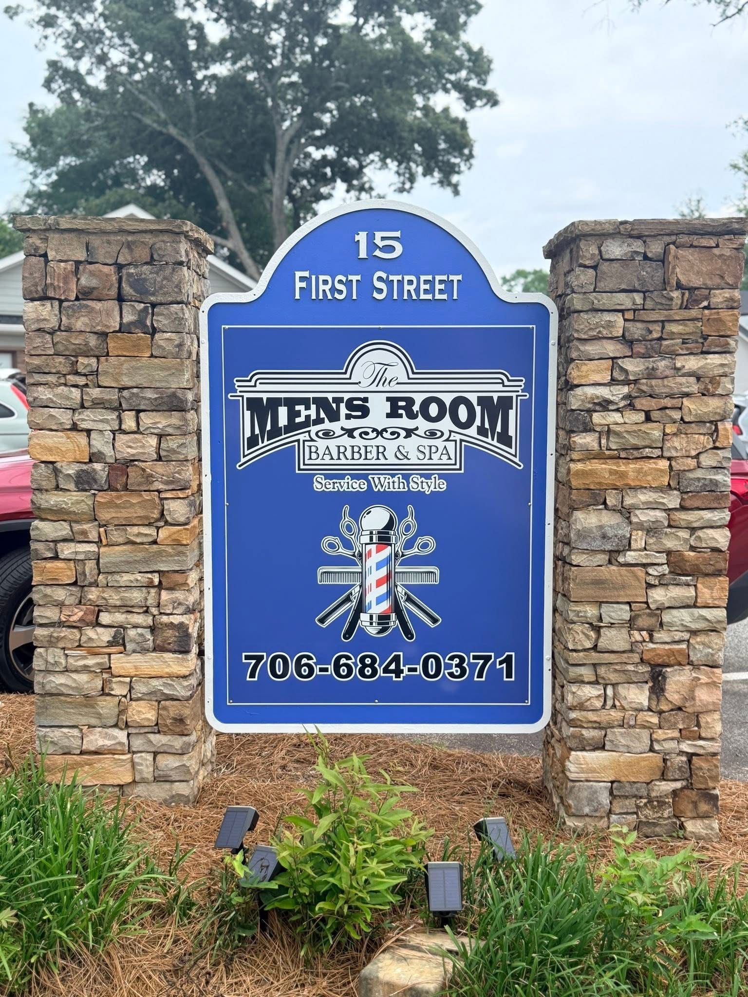 Blue sign for “The News Room” at 15 First Street between stone pillars.