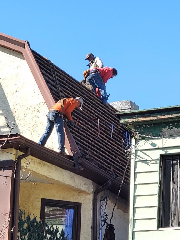 Two men are working on the roof of a house.