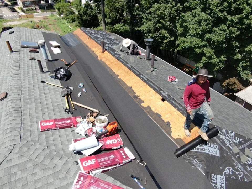 An aerial view of a roof with a man sitting on it