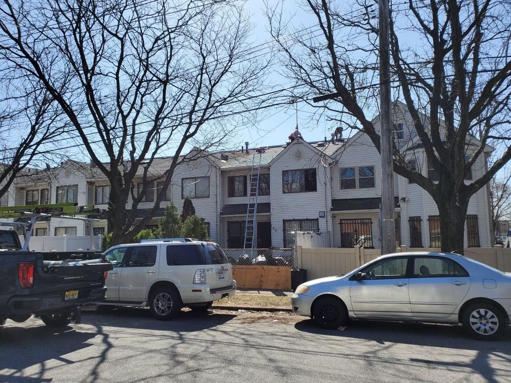 A row of houses with cars parked in front of them