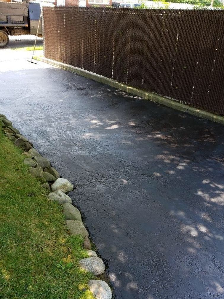 A driveway with a chain link fence along the side of it.