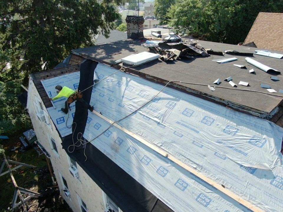A man is working on the roof of a building.