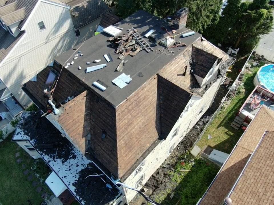 An aerial view of a house with a roof that has been damaged by a fire.