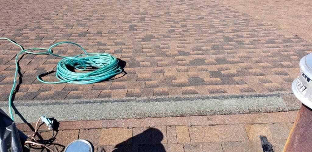 A hose is laying on the ground next to a fan.