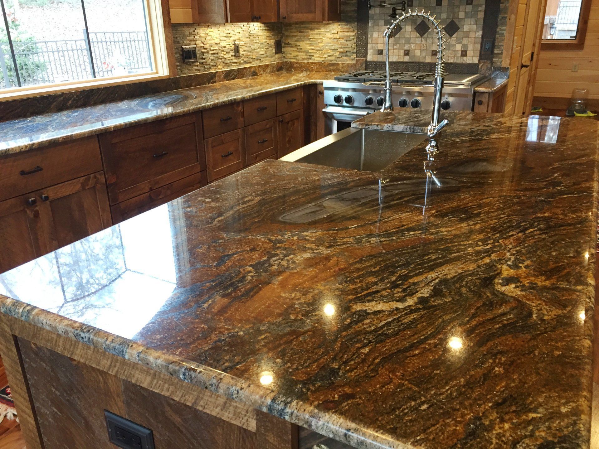A kitchen with granite counter tops and a stainless steel sink.