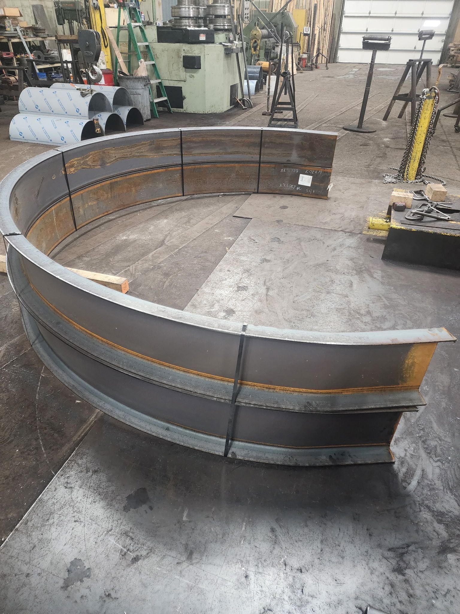 A large, curved metal structure in a workshop, likely for machinery.