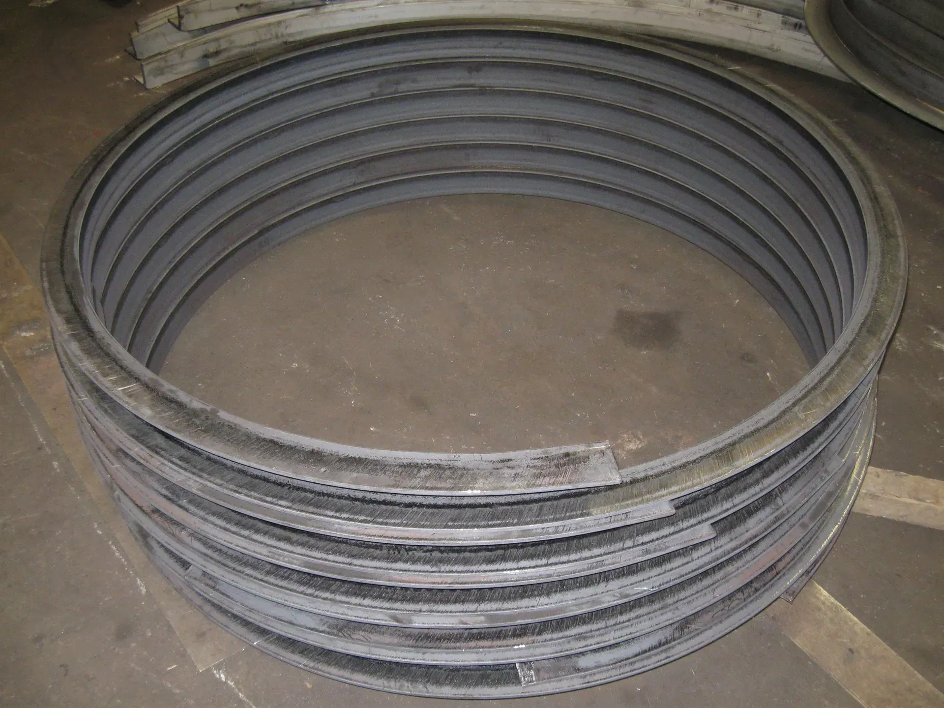 A stack of dark metal rings laying on a dark surface.