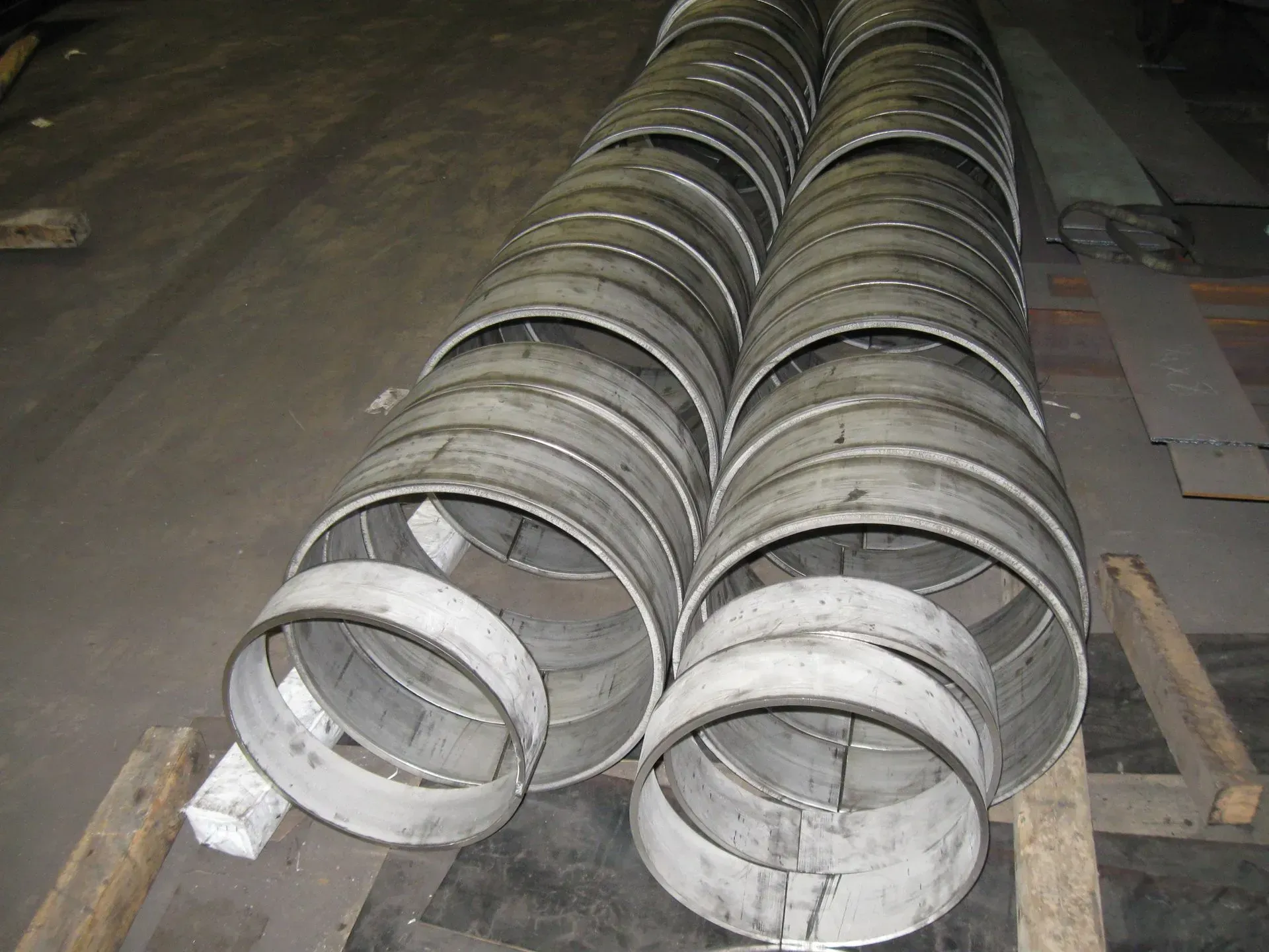 Metal cylinders stacked on a dark surface, potentially industrial setting.
