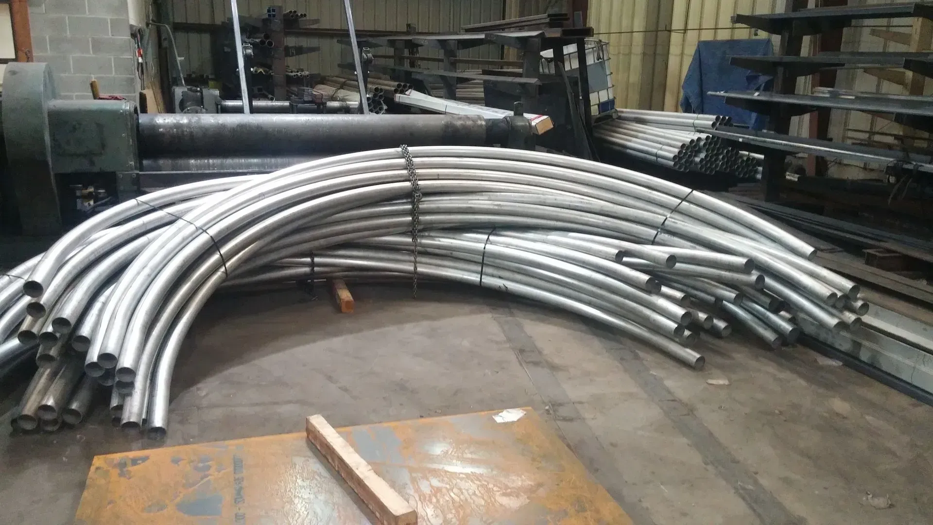 Bundle of curved metal pipes in a workshop setting.