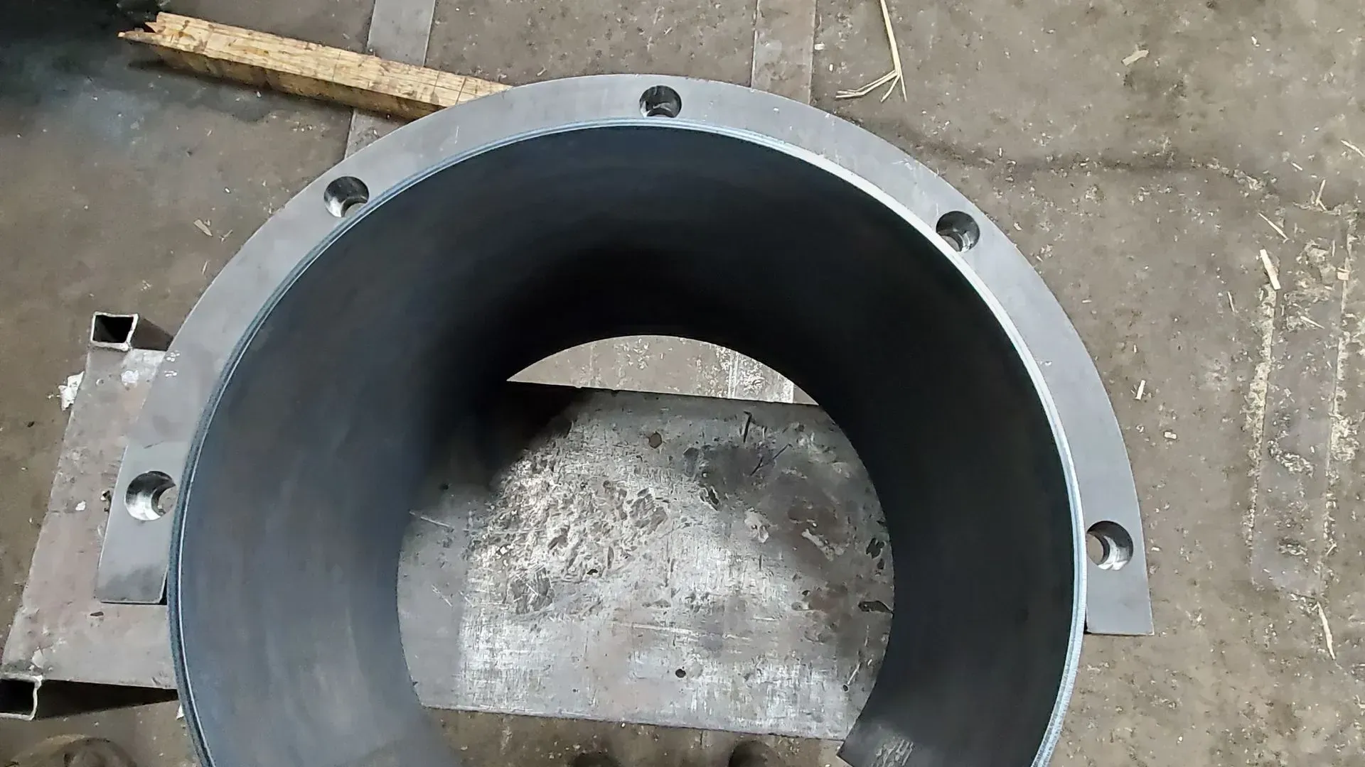Gray cylindrical metal part with bolt holes.