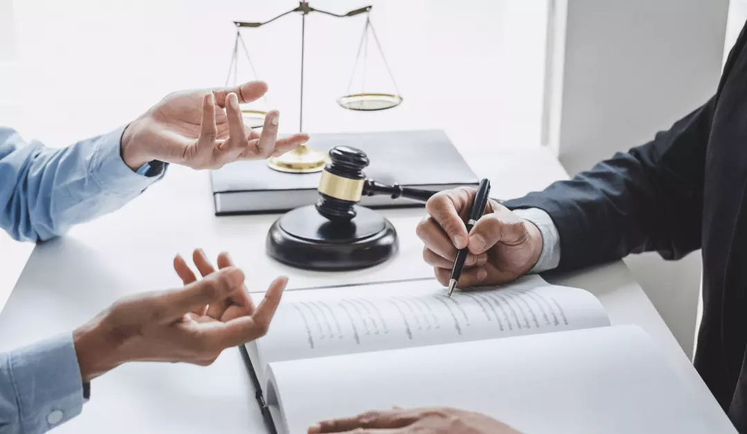 Lawyers discussing a case with scales of justice and gavel on a conference table