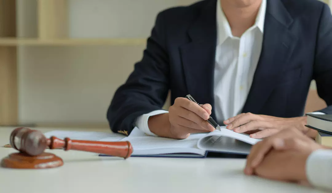 Lawyer taking notes beside a gavel during a meeting in an office