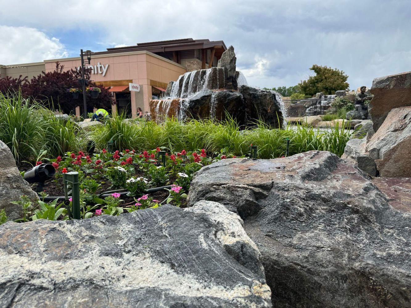 Water cascading over rocks in front of a building with