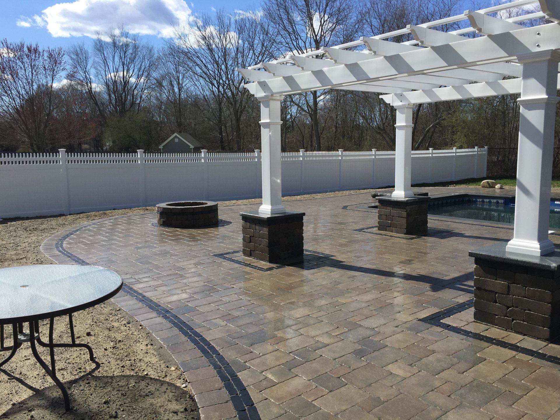 A patio with a pergola and a table and chairs