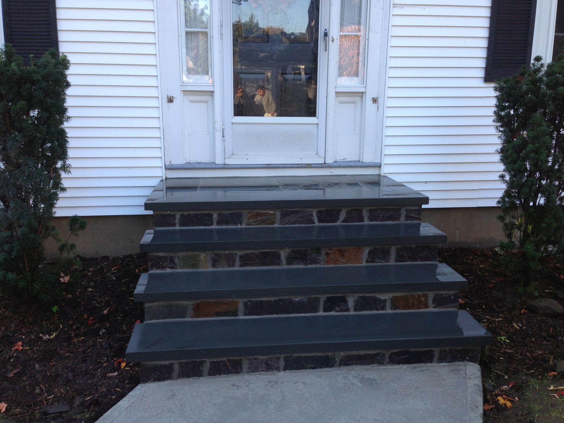 A white house with black steps leading up to the front door