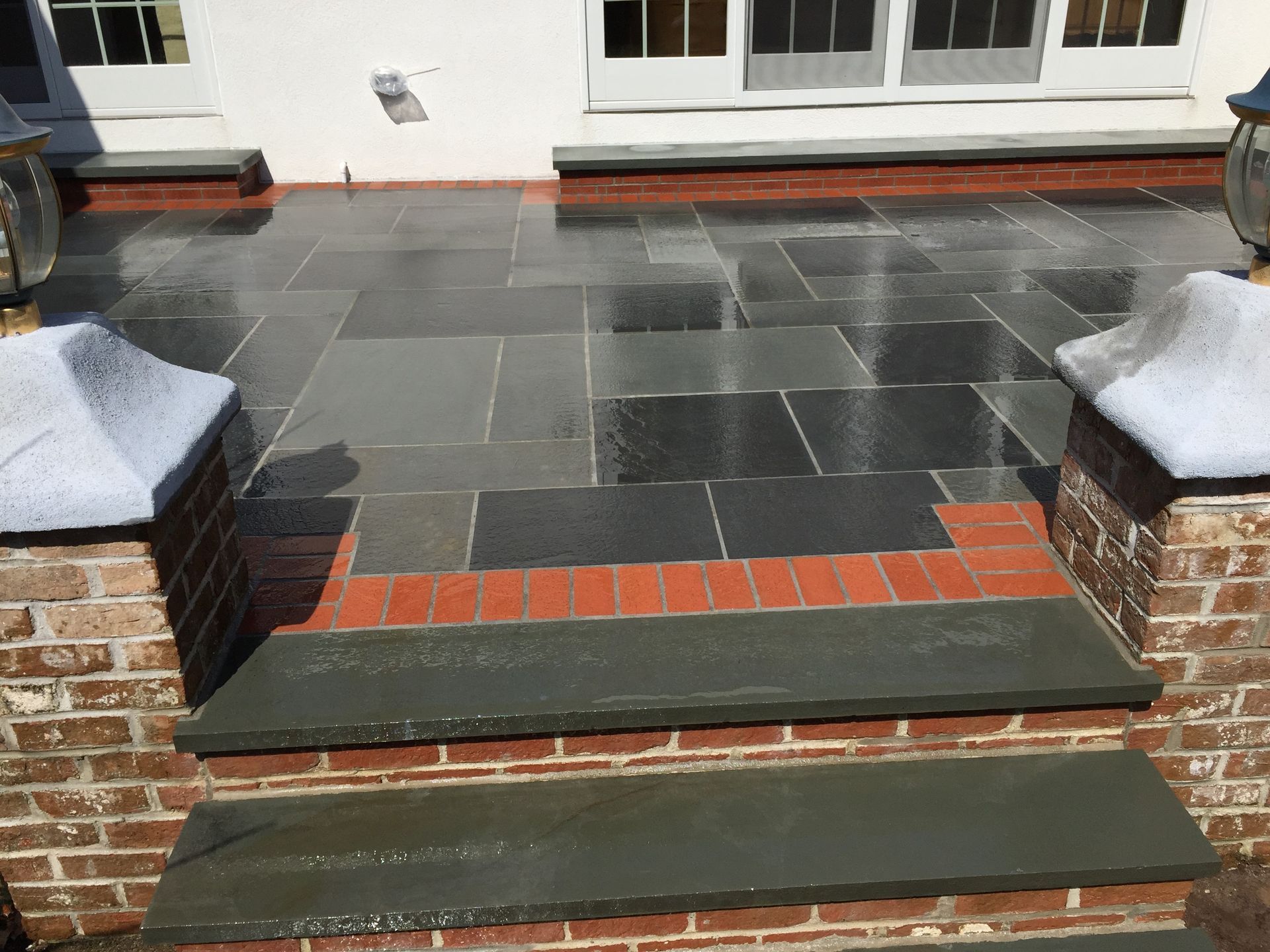 A stone patio with brick steps leading up to it