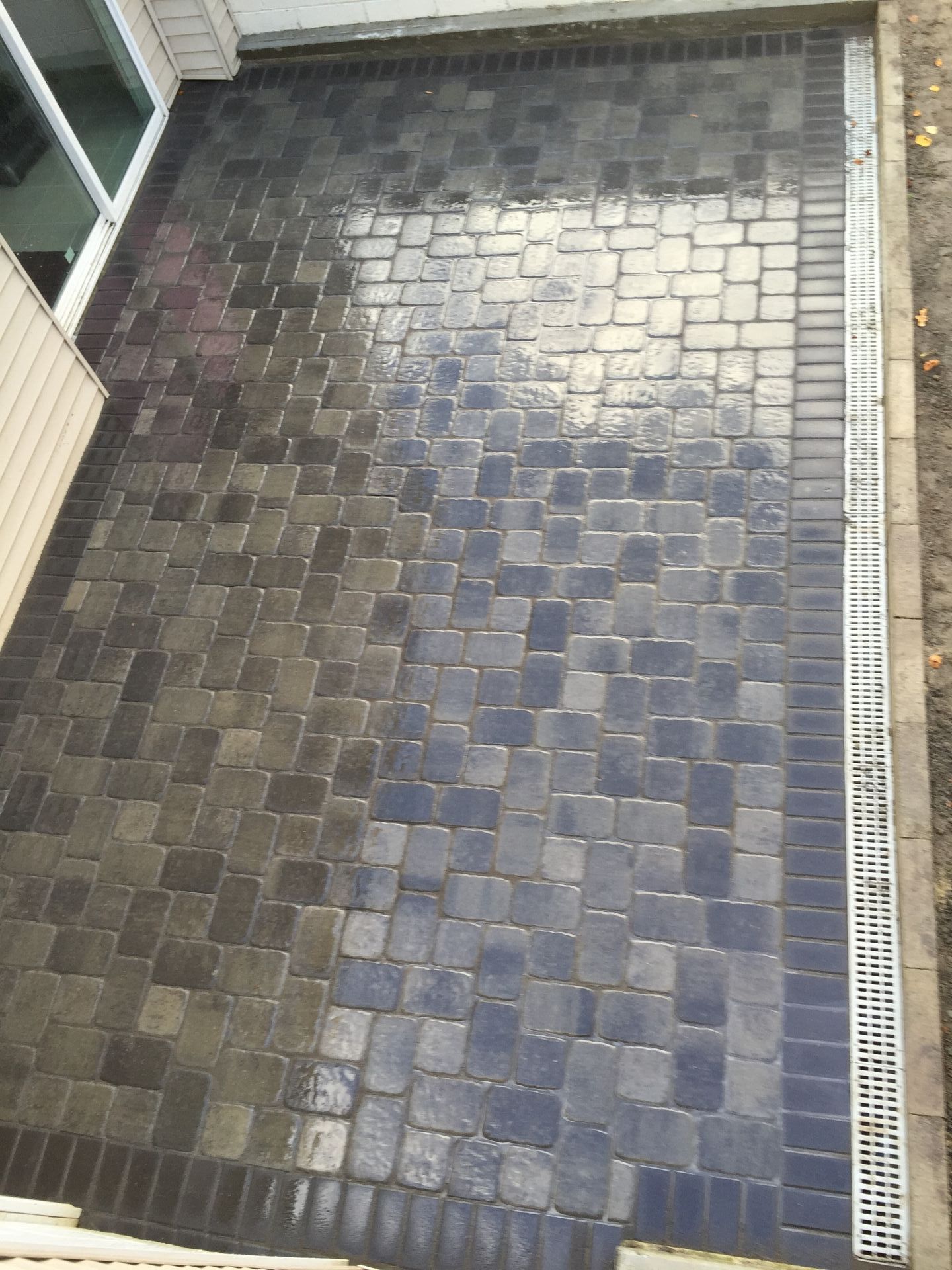 An aerial view of a brick patio with a drain.