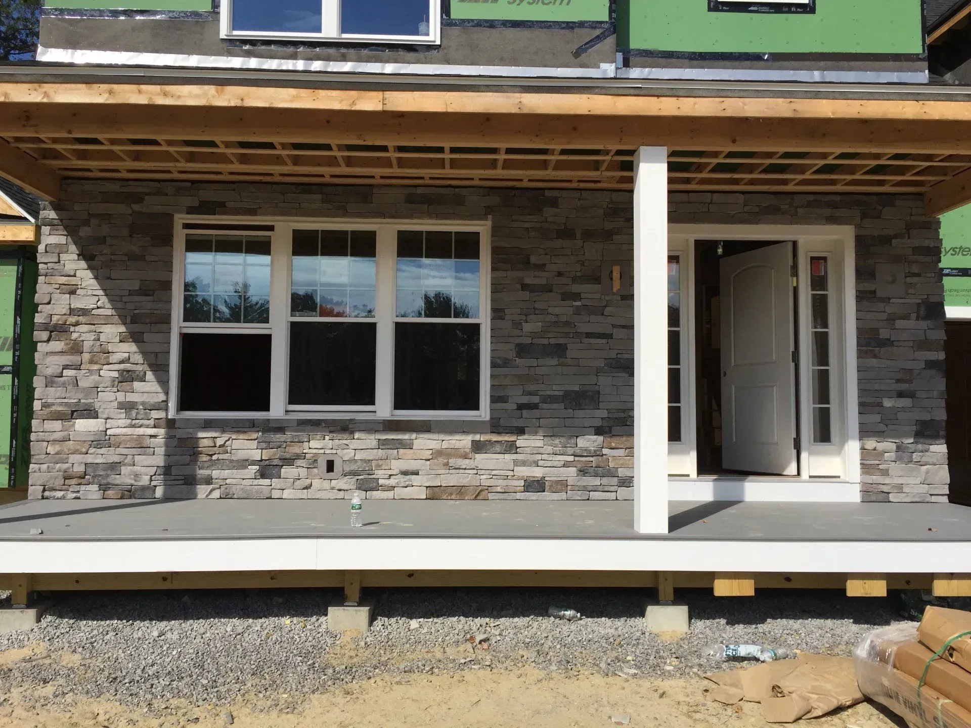 A house under construction with a porch and windows