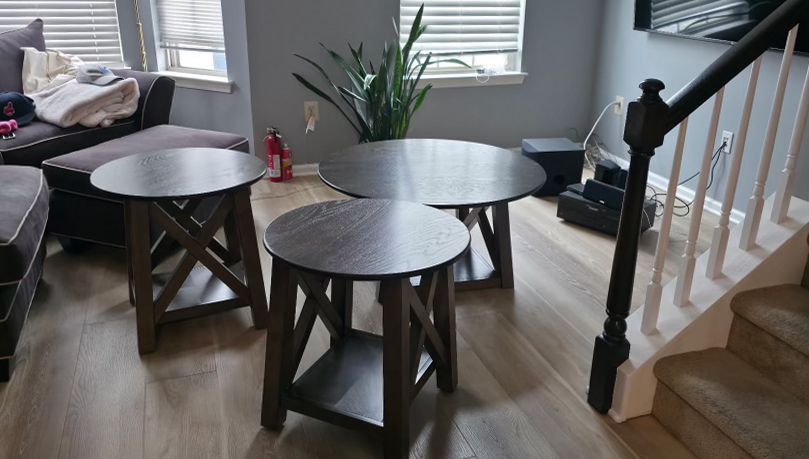 Small round wooden tables in a bright living room.