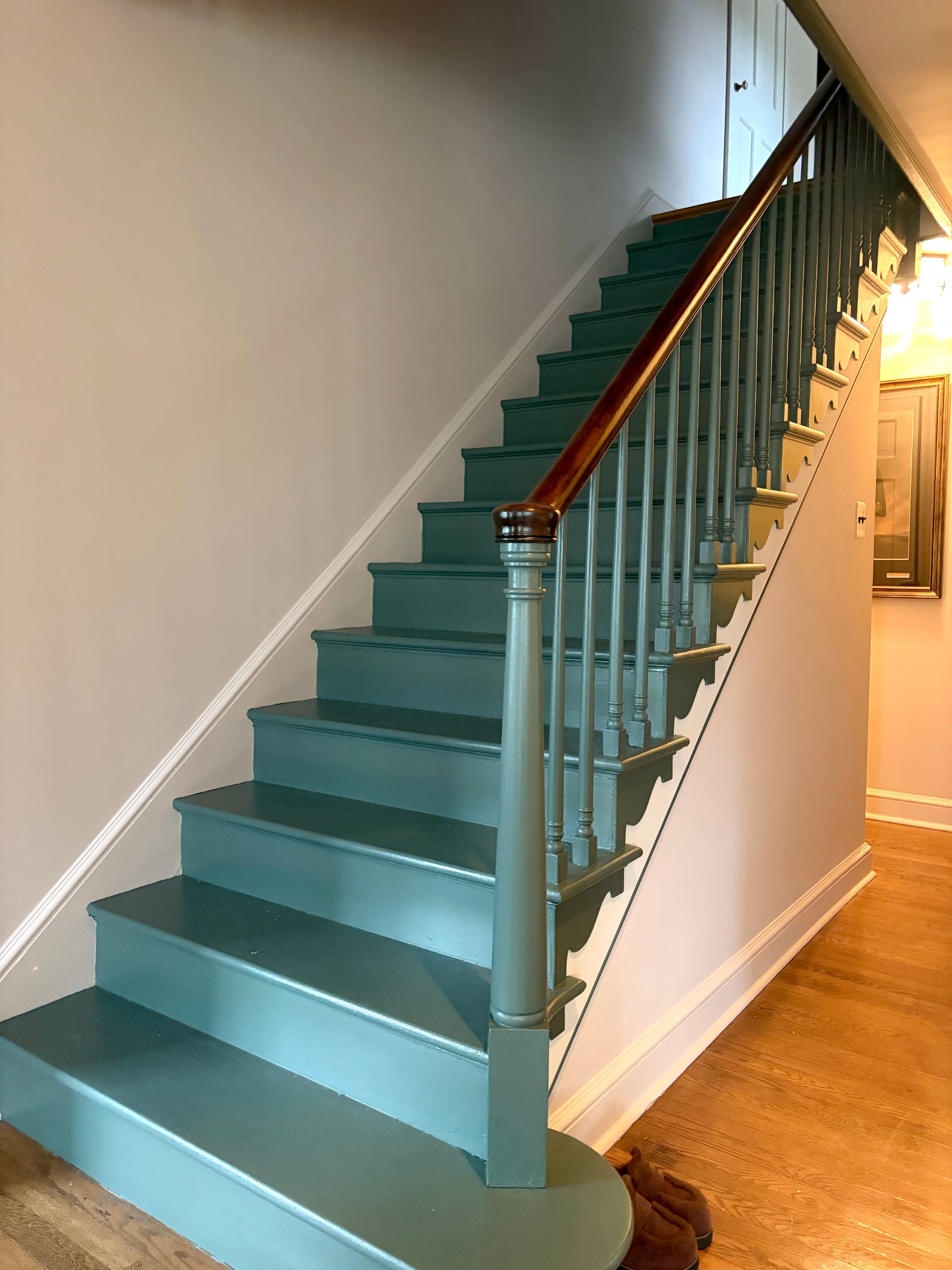 Teal staircase with wooden handrail in a home interior