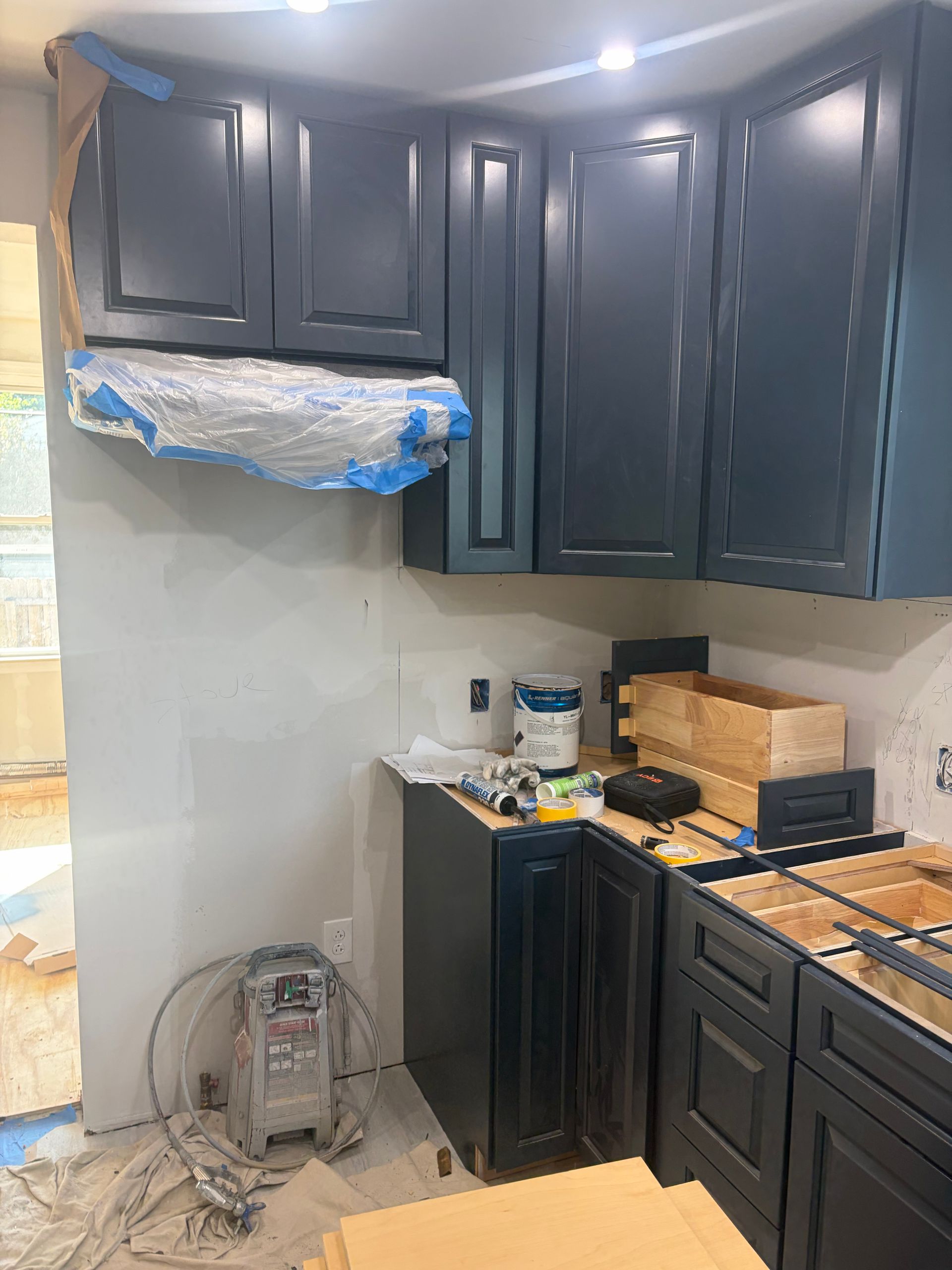 Small kitchen with dark cabinets, granite counters, and an unfinished backsplash area under renovation.