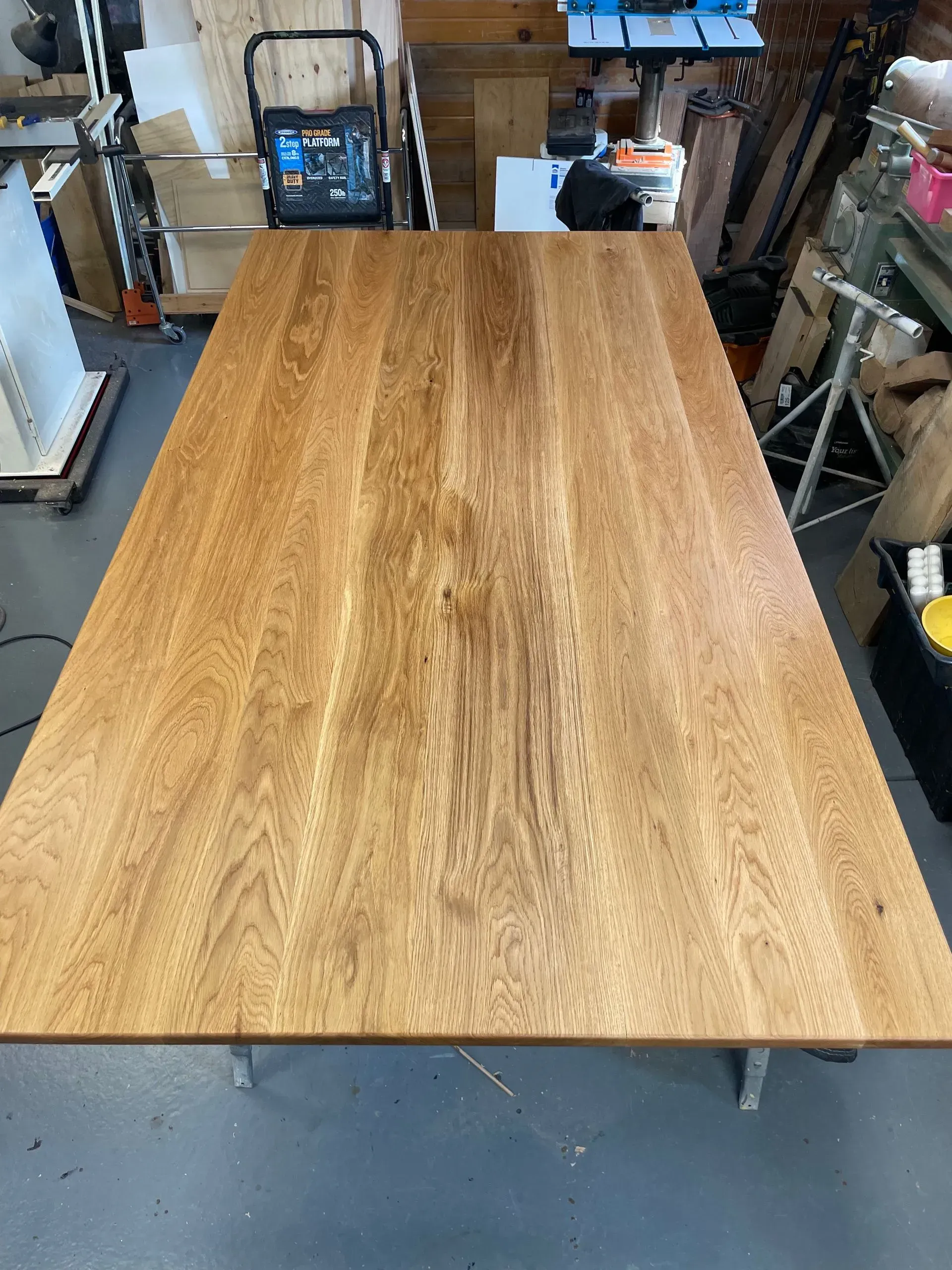 Wooden table in a workshop setting, made of several wood planks, brown.