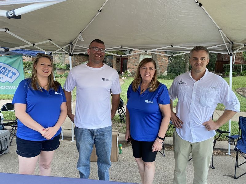 A group of people are posing for a picture under a tent.