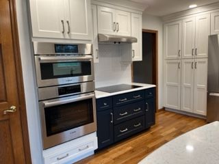A kitchen with stainless steel appliances and white cabinets