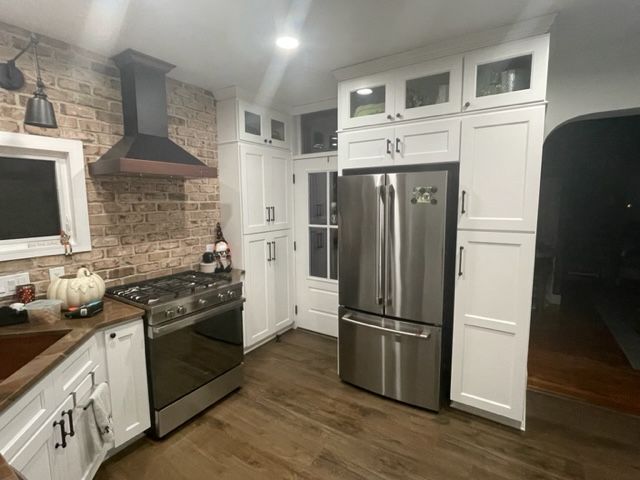 A kitchen with stainless steel appliances and white cabinets
