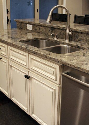 A kitchen with two sinks and a stainless steel dishwasher