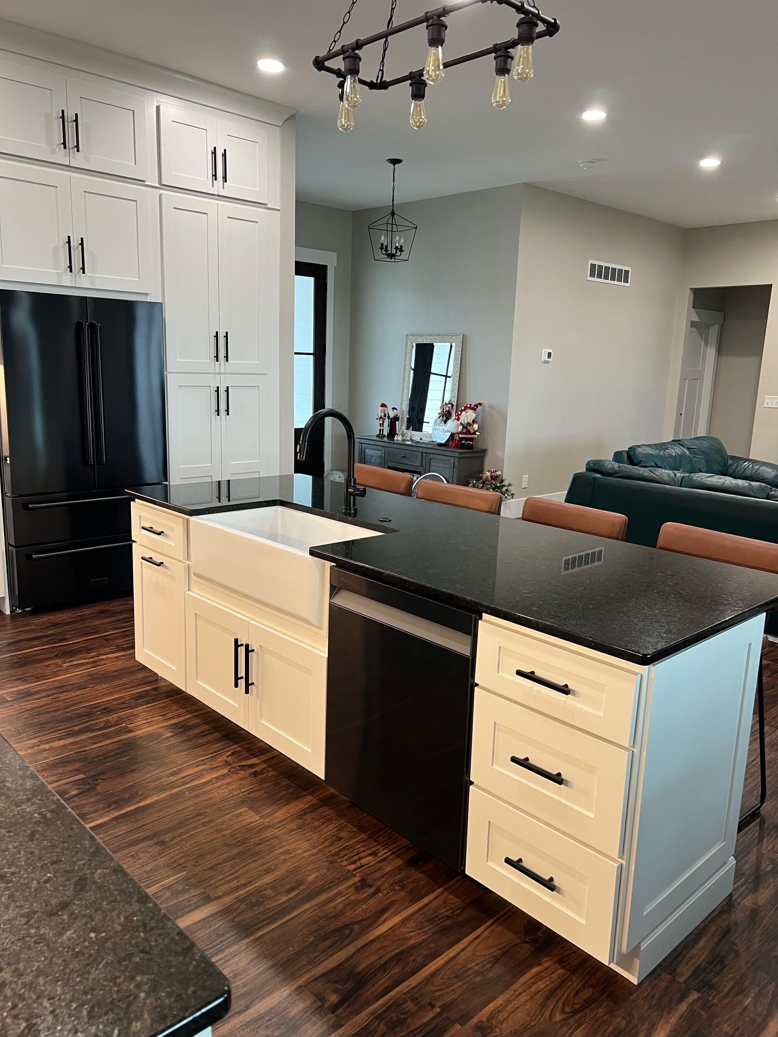 A kitchen with a large island, sink, refrigerator and dishwasher