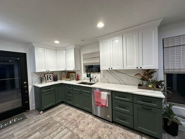 A kitchen with green cabinets and white counter tops