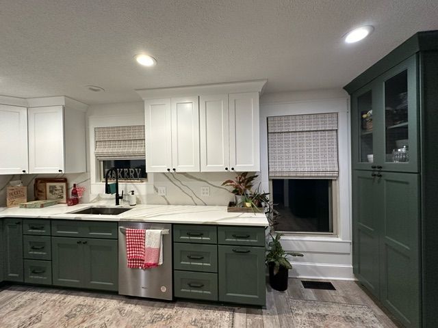 A kitchen with green cabinets and white cabinets