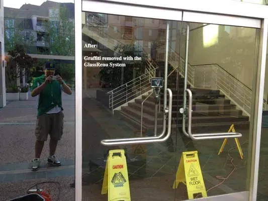 Person taking a photo in front of a glass door. Two yellow 