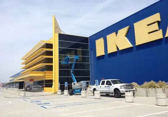 IKEA store exterior with yellow and blue facade, a lift, and a white truck.
