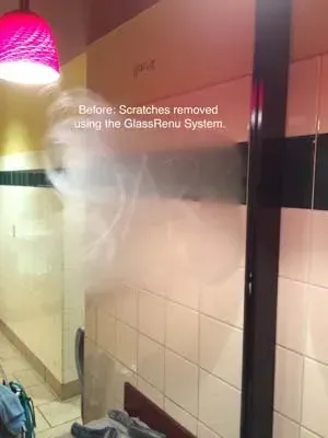A frosted glass panel with visible scratches and a text overlay indicating the scratches were removed using a system.