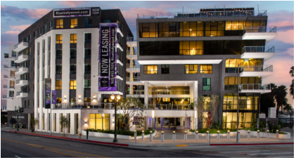 Modern multi-story apartment complex at dusk, with 