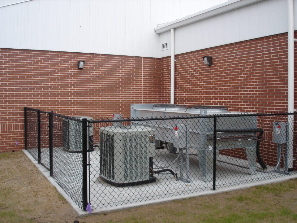 A brick building with a chain link fence around it