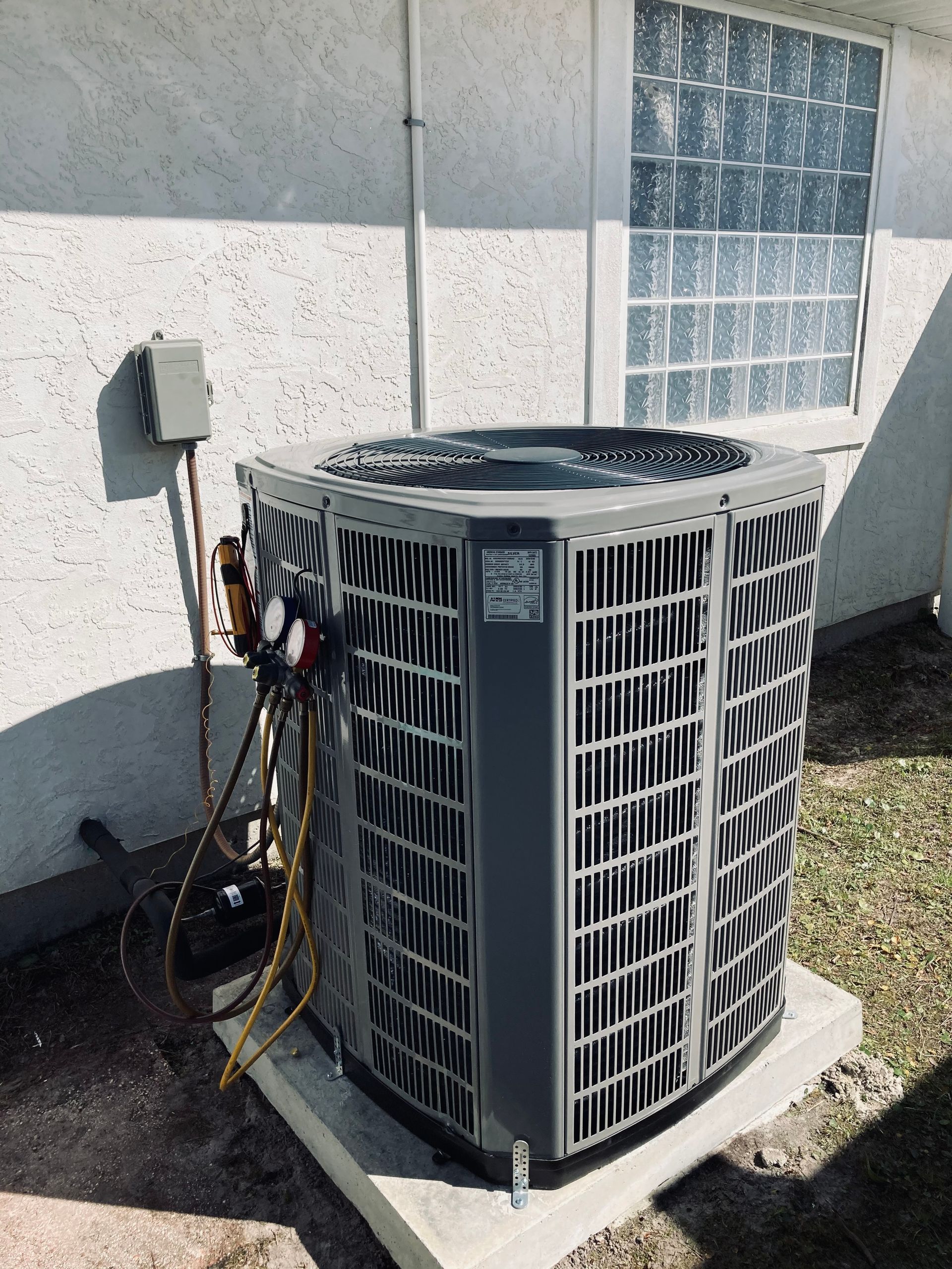 A large air conditioner is sitting outside of a house.